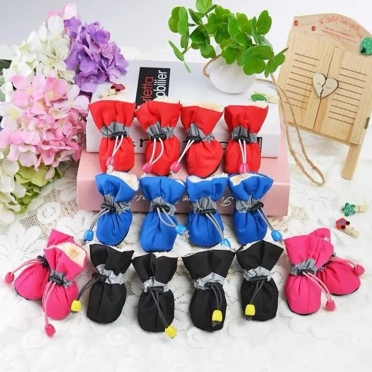Multicolour set of four breathable cloth dog shoes with non-slip soft bottom on a white background