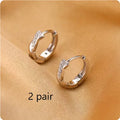 Women's geometric round earrings with interwoven hemp rope detail on a diamond-cut copper frame in gold colour.