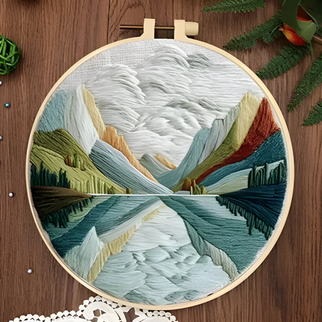 Embroidery kit with printed landscape design fabric, coloured thread, needles, and bamboo frame