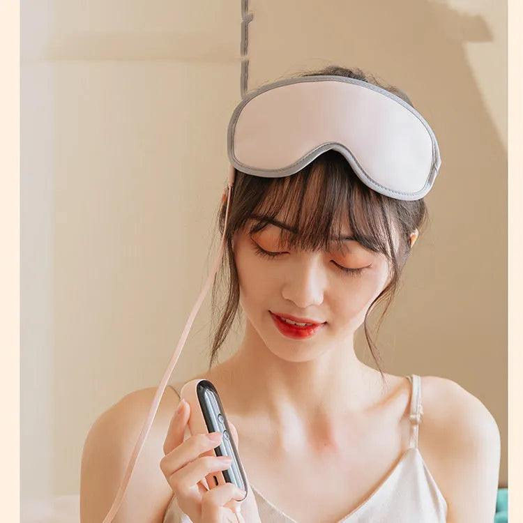 Green portable eye SPA massage goggles with USB cable on a white background.