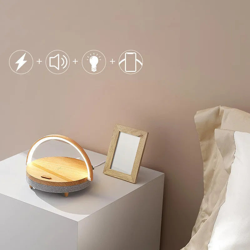 White multifunctional bedside lamp with wireless charging pad, Bluetooth speaker grille, and integrated phone holder in marble pattern finish.