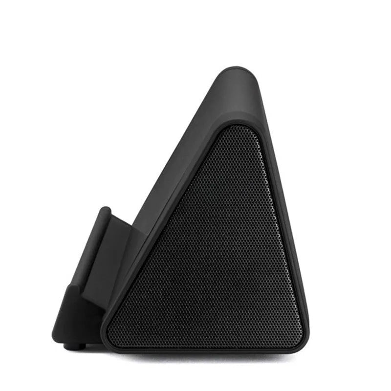 Compact black and white wireless mini Bluetooth speaker with built-in charging cable.