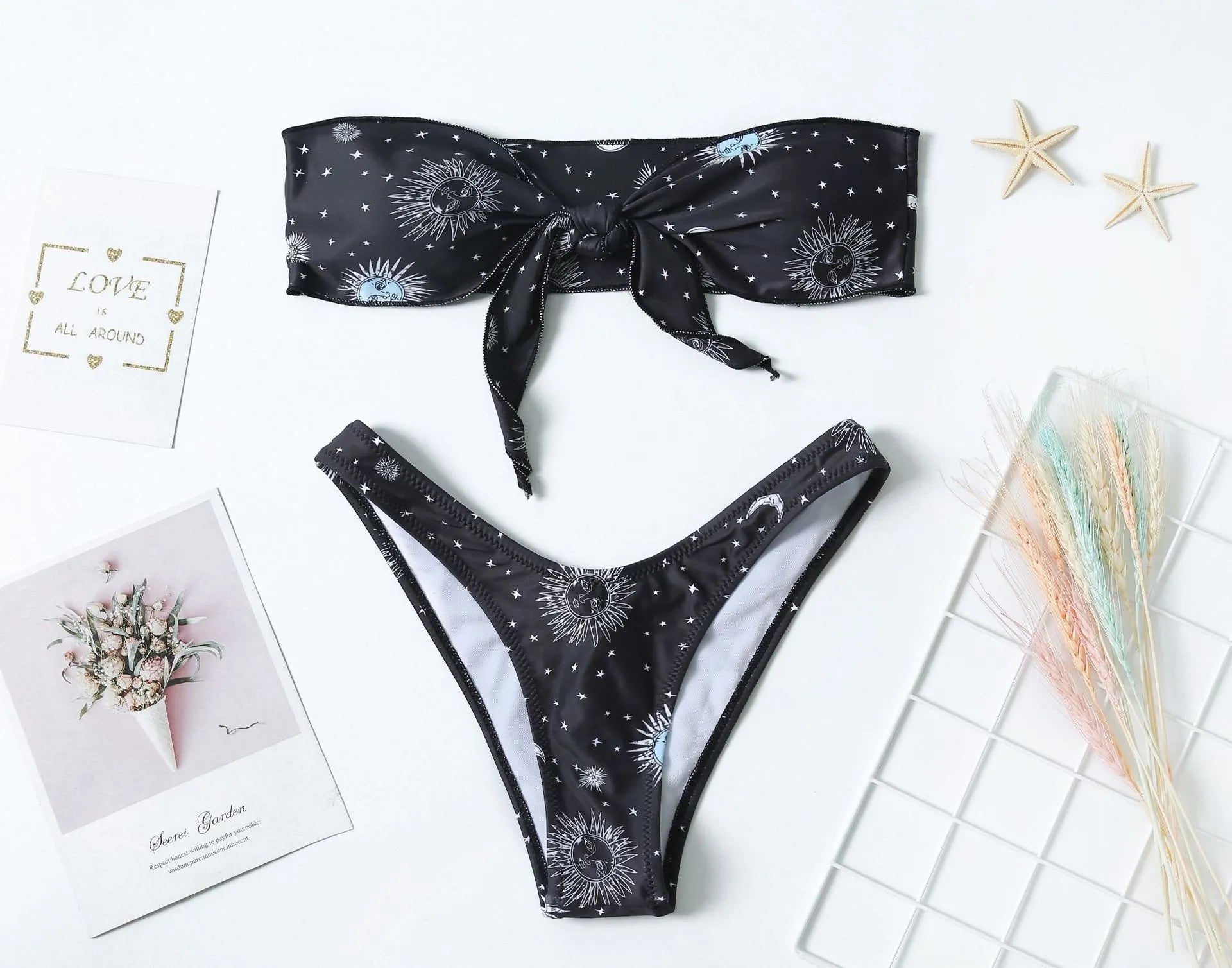 Black one-piece swimsuit with bikini print, featuring a split tube top and backless design.