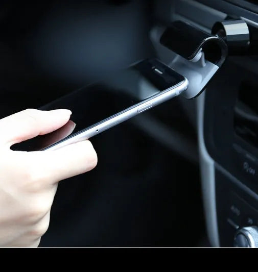 Black universal car phone holder with 360-degree rotation mounted on car dashboard holding smartphone