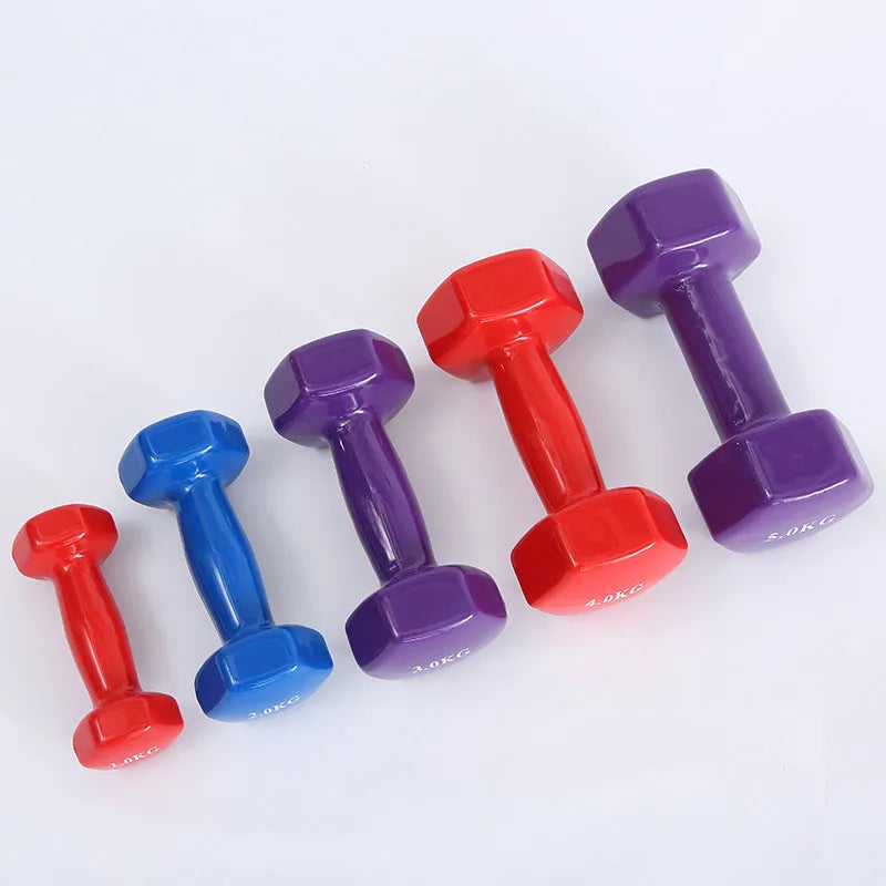 Bright colourful plastic dumbbell for fitness with glossy surface on wooden floor