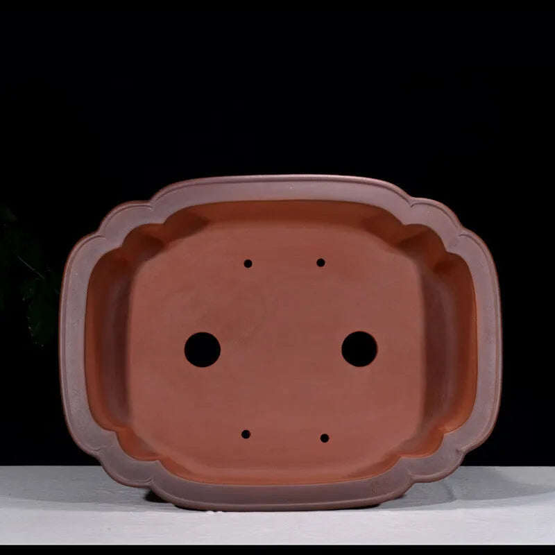 Antique-style purple clay flowerpot with Chinese decorative motifs showing tree stump, pine, cypress, pomegranate, golden marble, antique jade belt, and crabapple designs