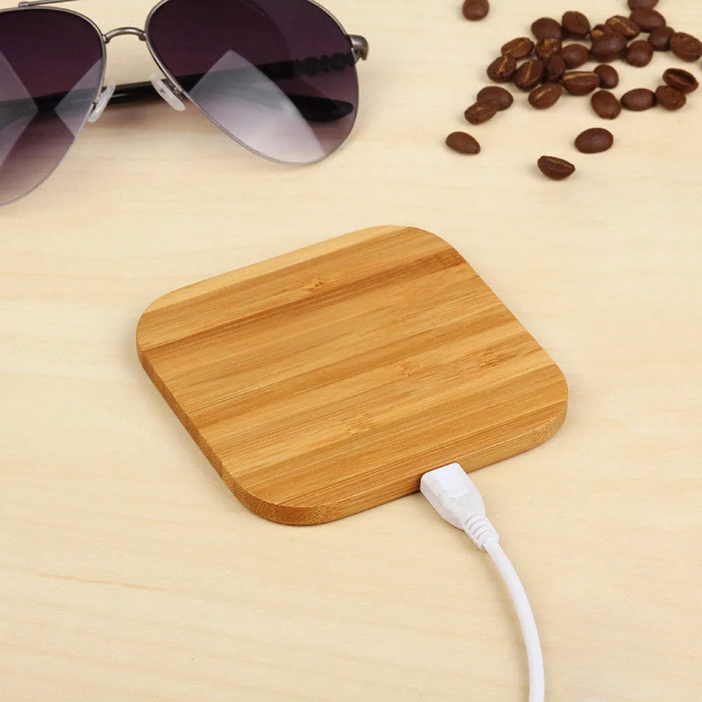 Square brown wooden bamboo wireless charging pad for phones on a desk