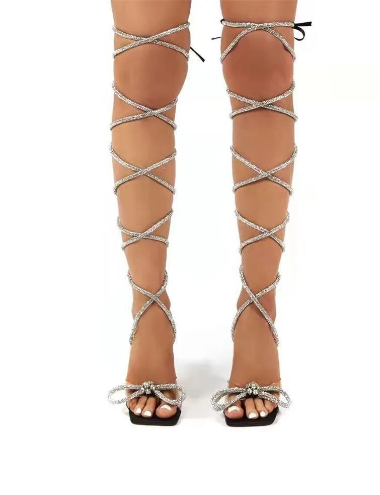 Plus size women's black strappy sandals with rhinestone detailing on Roman-style straps and a square toe