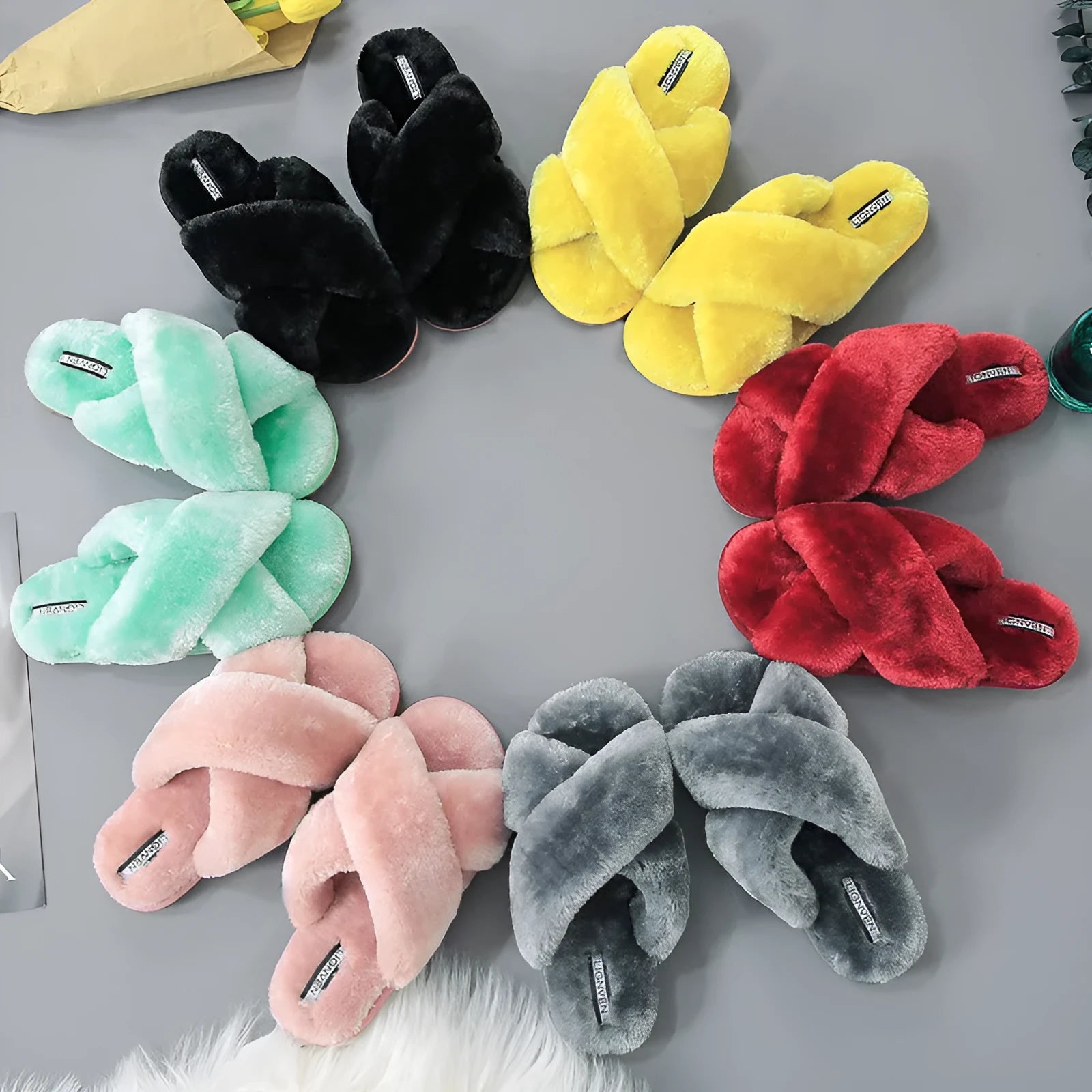 Cross open-toe fur slippers in various colours on a non-slip, patterned sole.