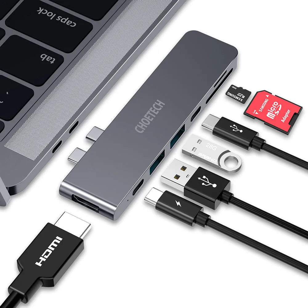 Silver aluminium USB-C 7-in-1 hub adapter with SD card, Micro SD, HDMI, USB 3.0, and Power Delivery ports.