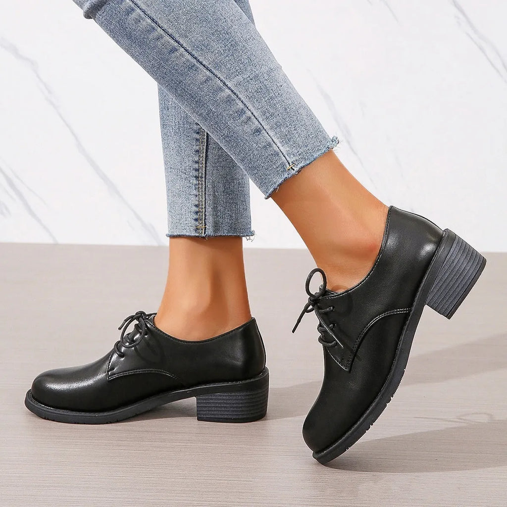 Black women's work shoes with a thick chunky heel and pointed toe.