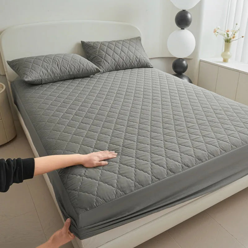 Diamond lattice quilted waterproof mattress protector in bamboo fibre, shown in a solid colour on a bed.