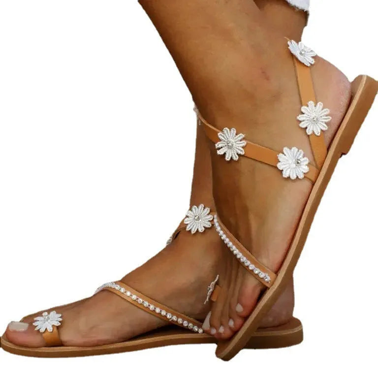 Brown women's sandals with flat rubber soles and decorative flower accents on the upper