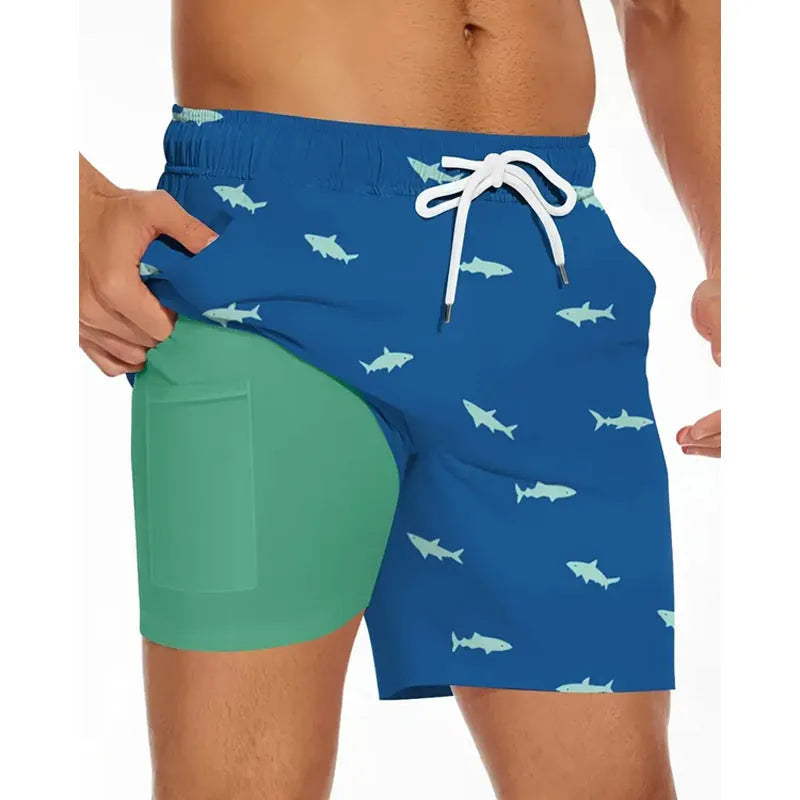 Man wearing loose grey polyester beach shorts on sand, showing casual fit.