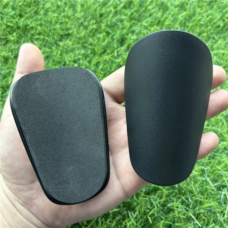 Extra small mini football shin guards measuring 8x5cm in black and white plastic