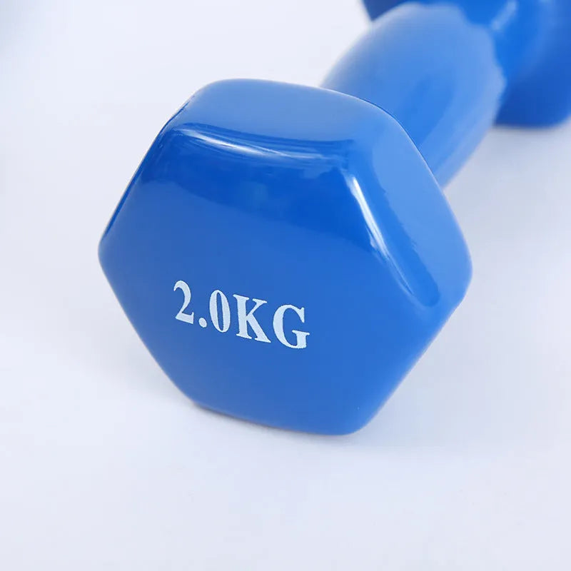 Bright colourful plastic dumbbell for fitness with glossy surface on wooden floor