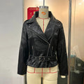 Punk style black leather jacket with Peter Pan collar, short belt, and drawstring waist.