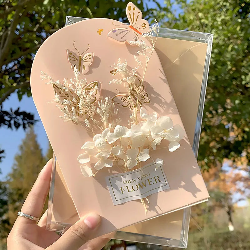 Handmade 3D boxed birthday card with butterfly shape and artificial flowers on coated paper.