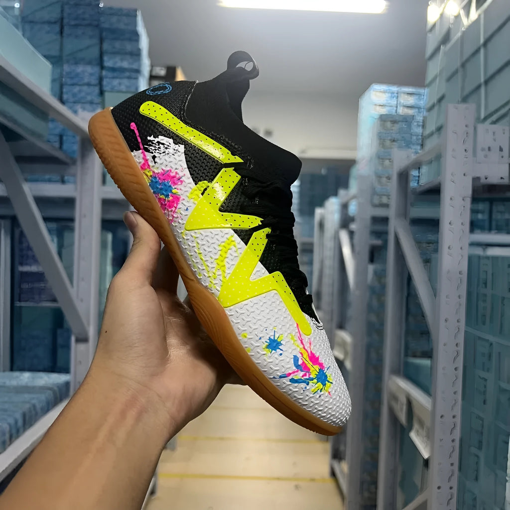 Low-top football shoes in black and yellow colour with PVC upper and rubber sole
