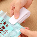 Household food clip portable mini plastic bag sealer heat sealing machine in pink on white background