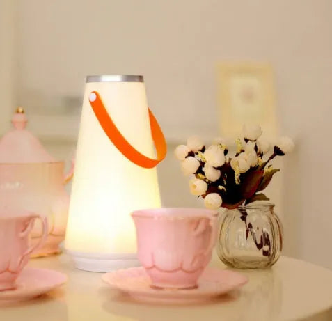 White rechargeable LED night light lantern on bedside table measuring 12x12x22cm with warm light