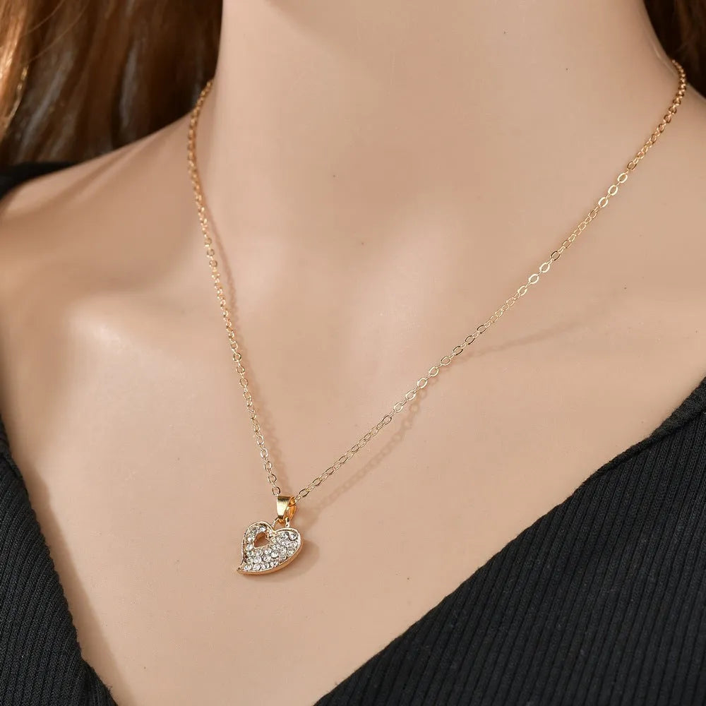 Women's gold alloy jewellery set with earrings, necklace featuring love pendant, and matching bracelet
