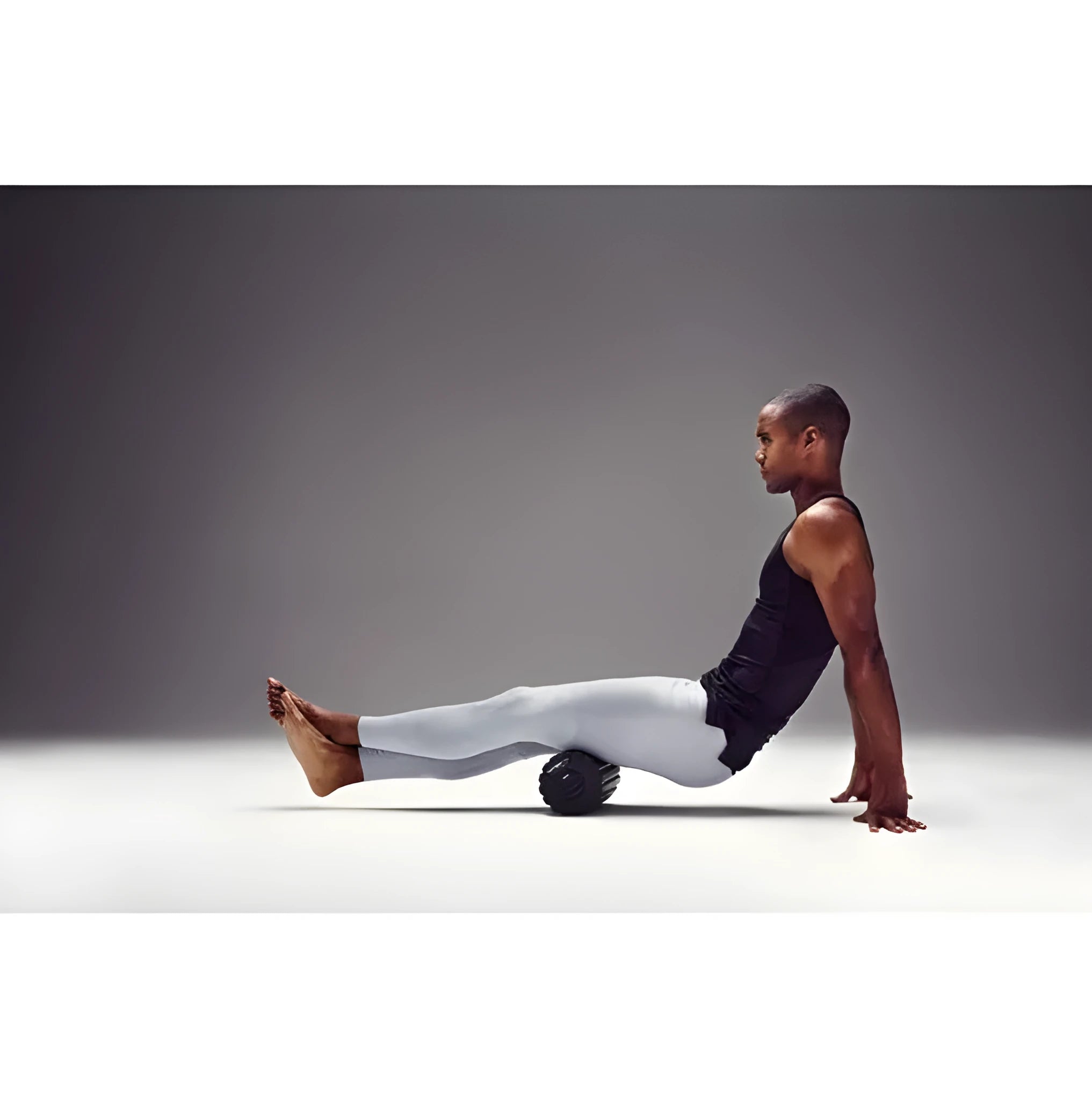 Black 4 speed vibrating massage roller foam on a floor for muscle recovery use