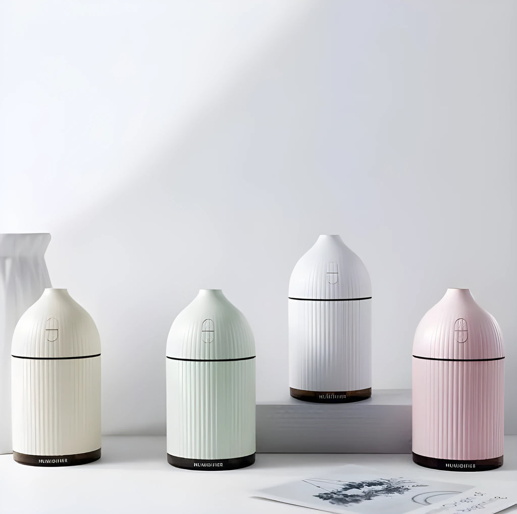 White ultrasonic aromatherapy diffuser and humidifier with LED light on a wooden surface