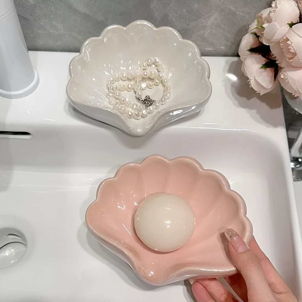 Pearl white plastic shell-shaped soap dish with drainage channels measuring 12cm long