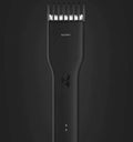 Black and white cordless hair clipper with adjustable comb and ceramic cutter head on a plain background