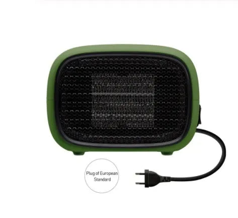 Mini green PTC ceramic fan heater on a desk showing compact size