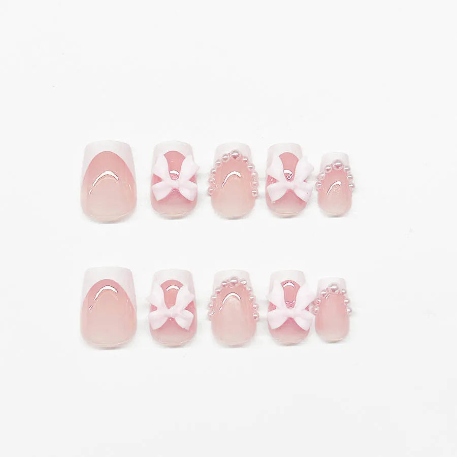 Short white French manicure press-on nails with decorative bow designs and European square shape