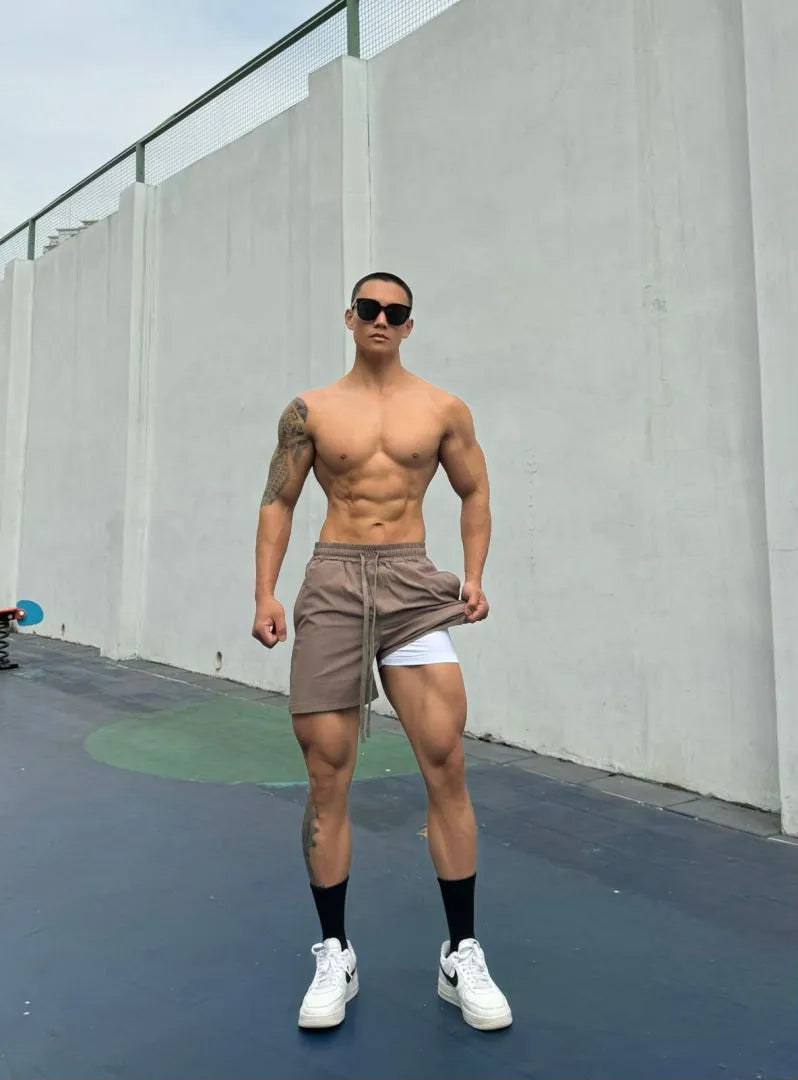 Men's ice silk quick-drying double-layer shorts in quarter-length fit on a hanger.