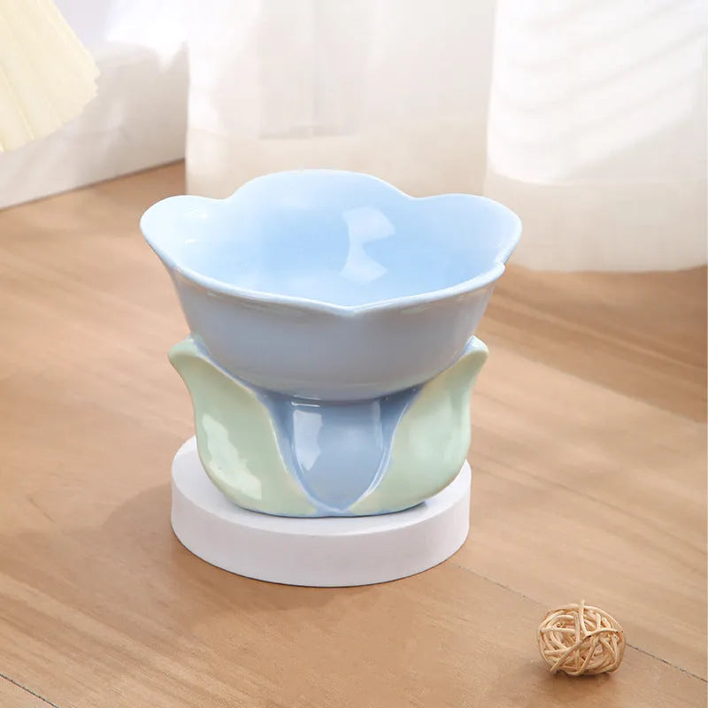 Blue ceramic pet bowl with floral pattern, raised on a non-slip base for cat or small dog feeding.