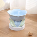 Blue ceramic pet bowl with floral pattern, raised on a non-slip base for cat or small dog feeding.