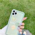 Green TPU iPhone case with geometric smiley face and polka dot design on a table.