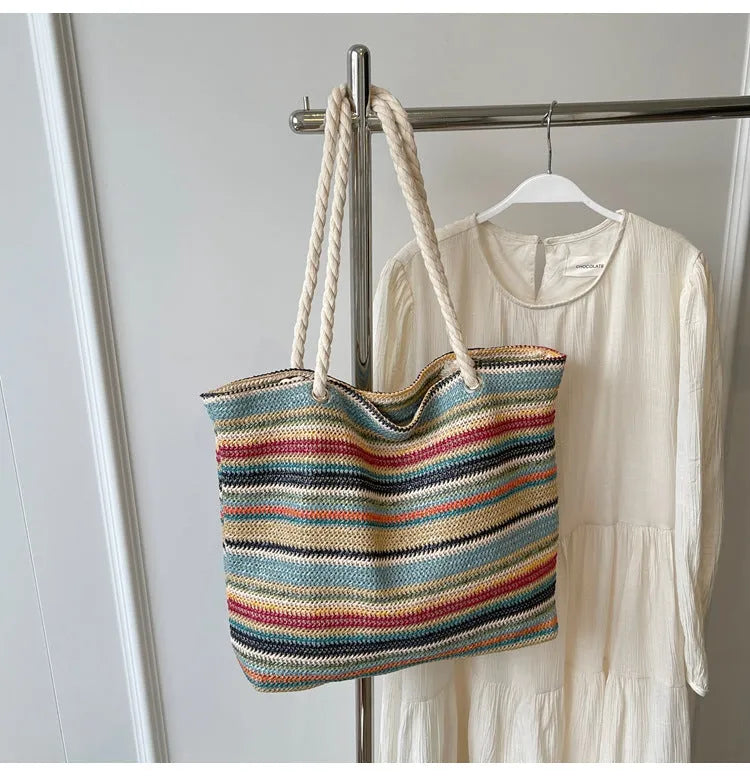Blue woven shoulder bag with straw and nylon construction showing adjustable straps and textured exterior