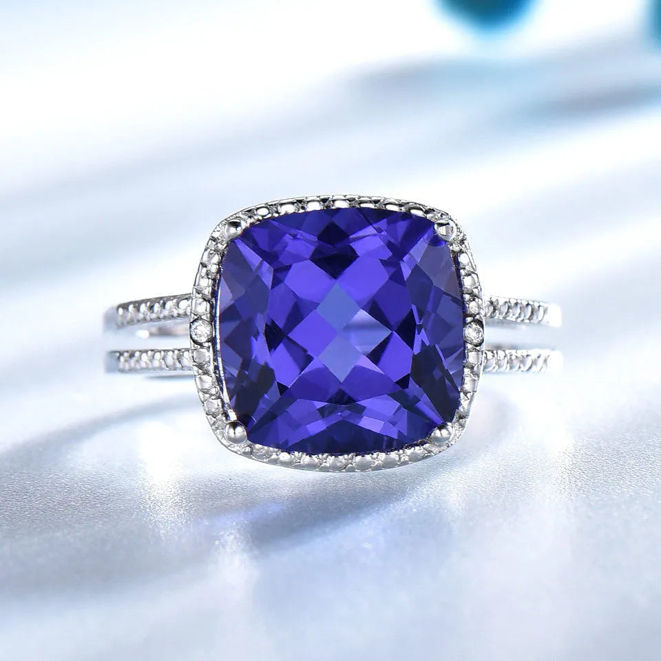 Blue tanzanite gemstone set in a sterling silver women's ring on a grey background