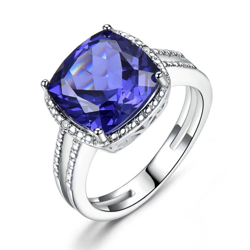 Blue tanzanite gemstone set in a sterling silver women's ring on a grey background