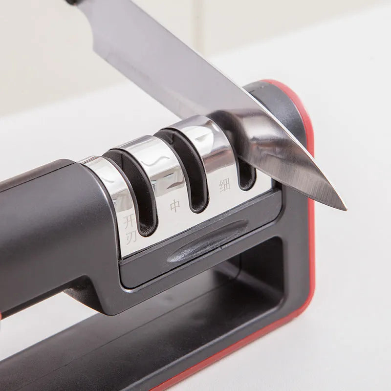 Black and red three-stage knife sharpener with non-skid rubber feet on a worktop