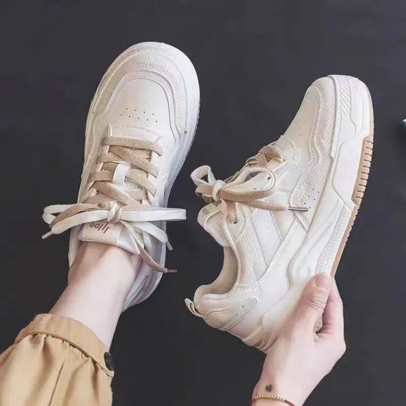 Pink and white low-top sneakers with rubber soles and imitation leather lining