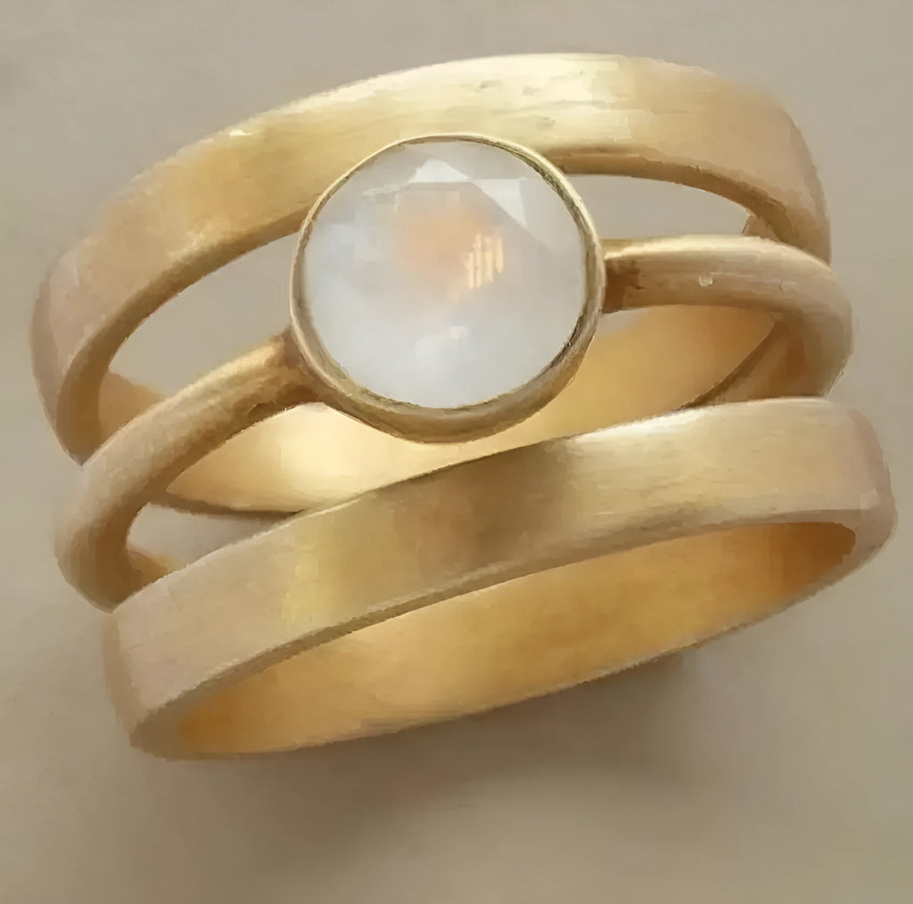 Gold geometric titanium steel ring with white chalcedony stone in a hollow micro-inlaid setting.