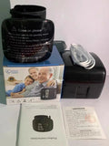 Black wrist blood pressure monitor with USB charging cable on a table.