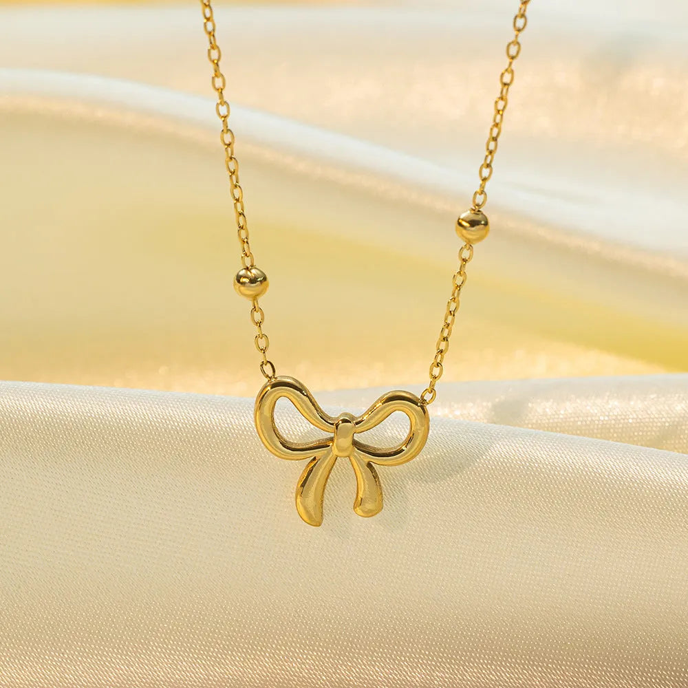 Gold electroplated bow pendant necklace on adjustable titanium steel chain