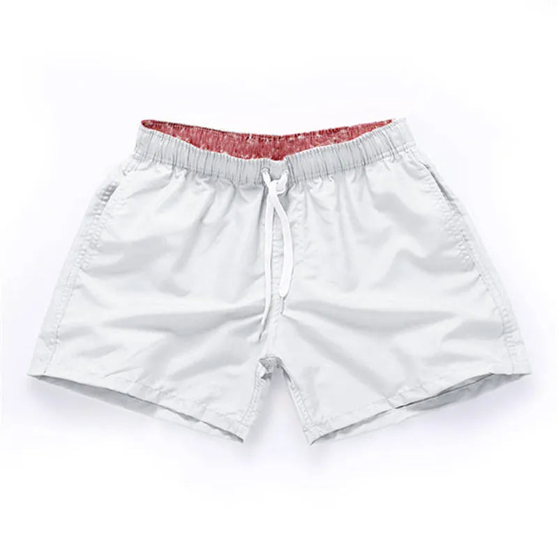 Men's polyester straight-leg surf shorts on a hanger, available in multiple solid colours.
