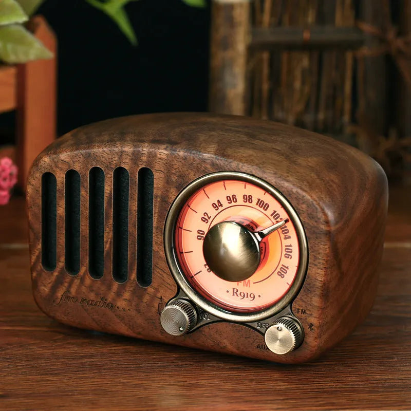 Retro wooden wireless mini speaker in cherry wood finish on a wooden table.