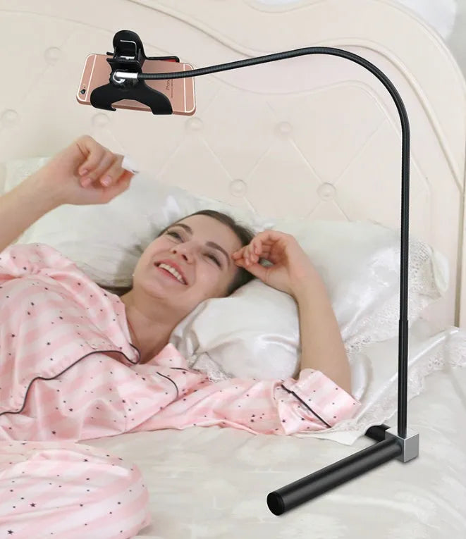 Black mobile phone bracket mounted on bed frame holding smartphone for comfortable viewing