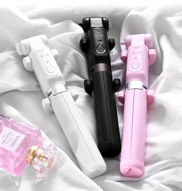 Black Bluetooth selfie stick tripod with remote control extended, holding a smartphone