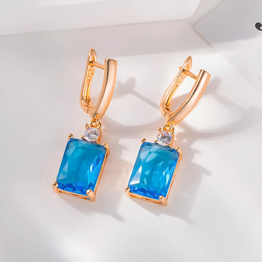 A pair of square gold and silver electroplated copper earrings showing geometric quadrilateral shape.