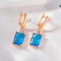 A pair of square gold and silver electroplated copper earrings showing geometric quadrilateral shape.